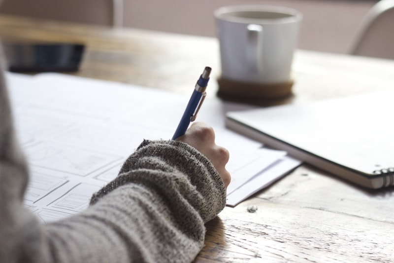 Person writing a daily plan at a desk